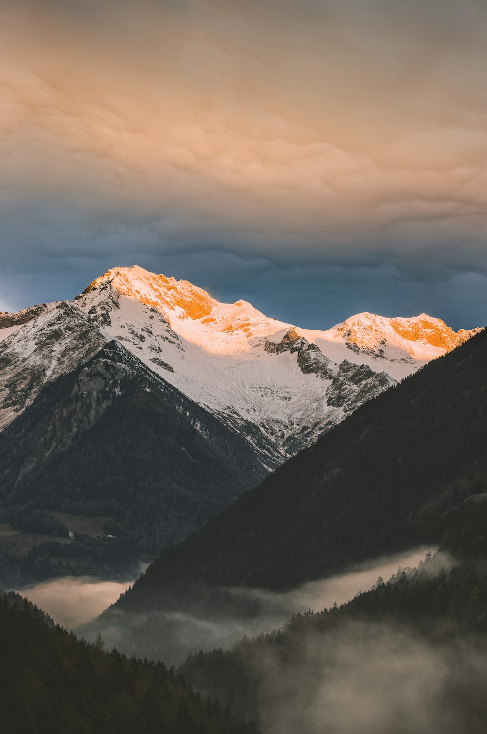 mountain covered with snow under white skies