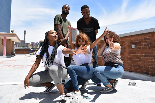A group photo of collaborators wearing deetroyt collective apparel at a rooftop gathering overlooking the city skyline.
