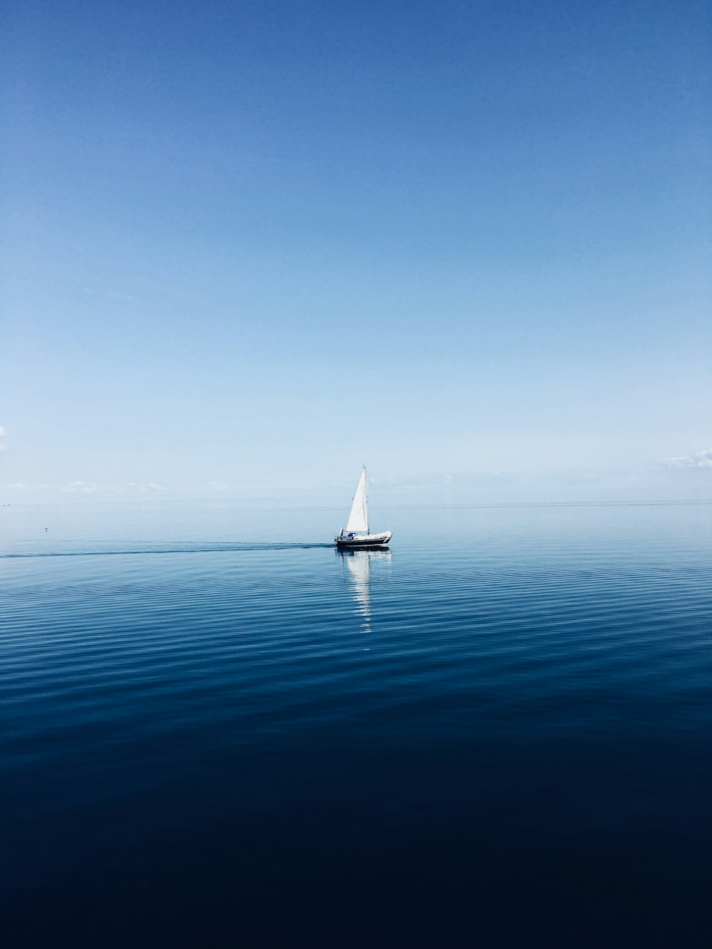weißes Segelboot mitten auf dem Ozean