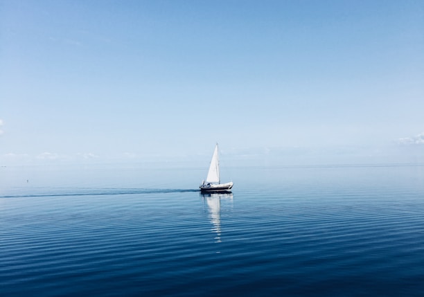 white sailboat at middle of ocean