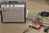 Electric guitar plugged into Tube Preamp B on a desktop, capturing the rich, clear tone in a musician’s workspace.