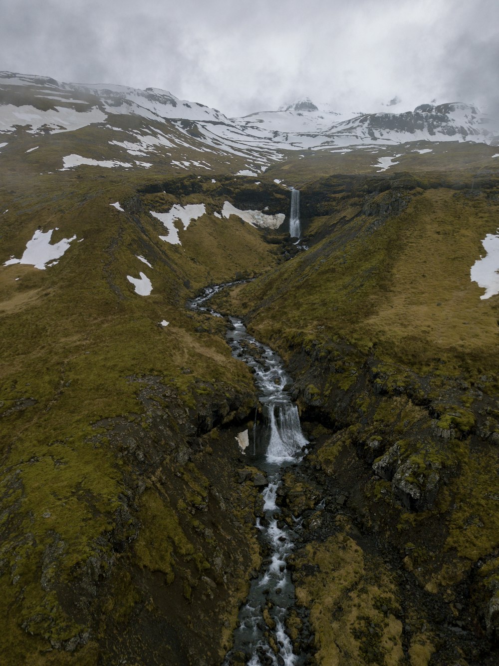 waterfall and river between hills