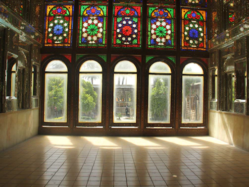 A vibrant music studio corner with colorful stained glass windows inspired by Gaudí's modernism.