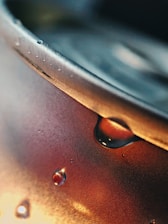 A close-up of an Enemy Ender can with condensation, sitting on a rustic wooden table.