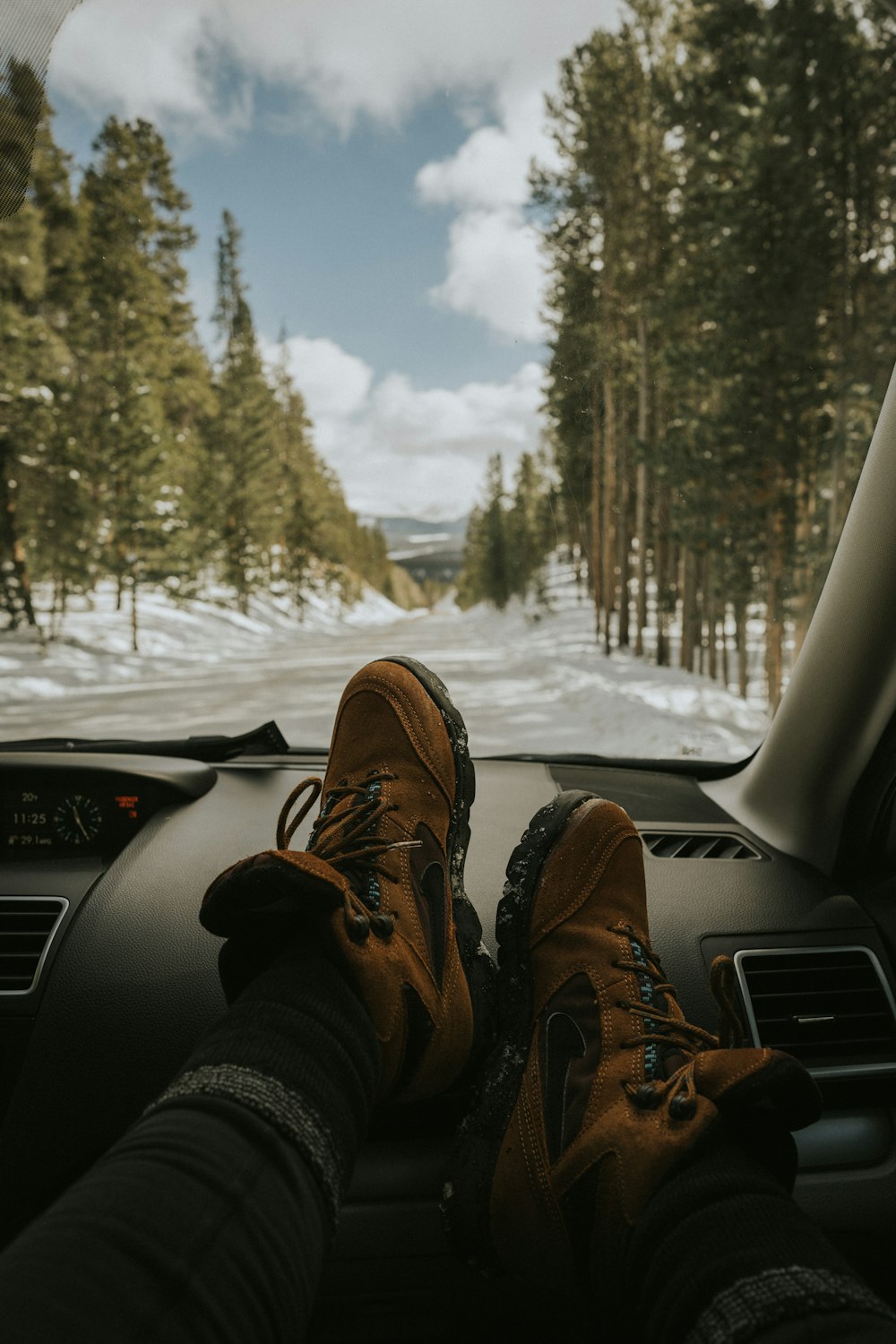 man resting his feet on vehicle dashboard