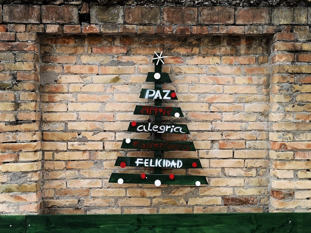 green, white, and red wooden Christmas tree mounted on brown wall