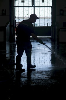 Technician using a high-powered water extractor inside a flooded residential basement.