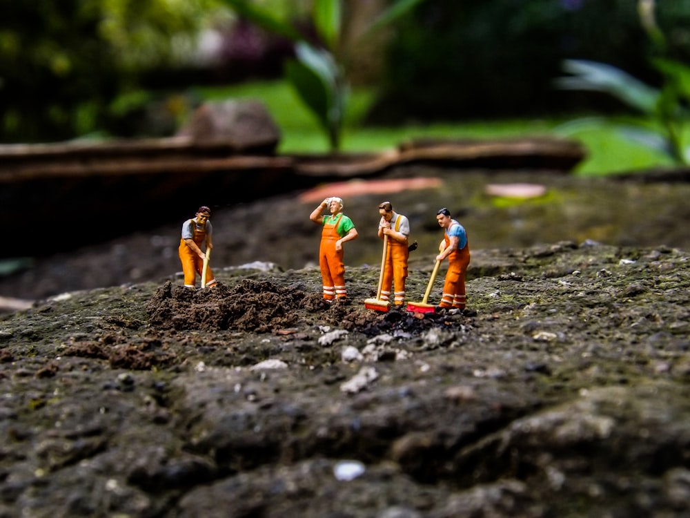 four men holding mops figurines