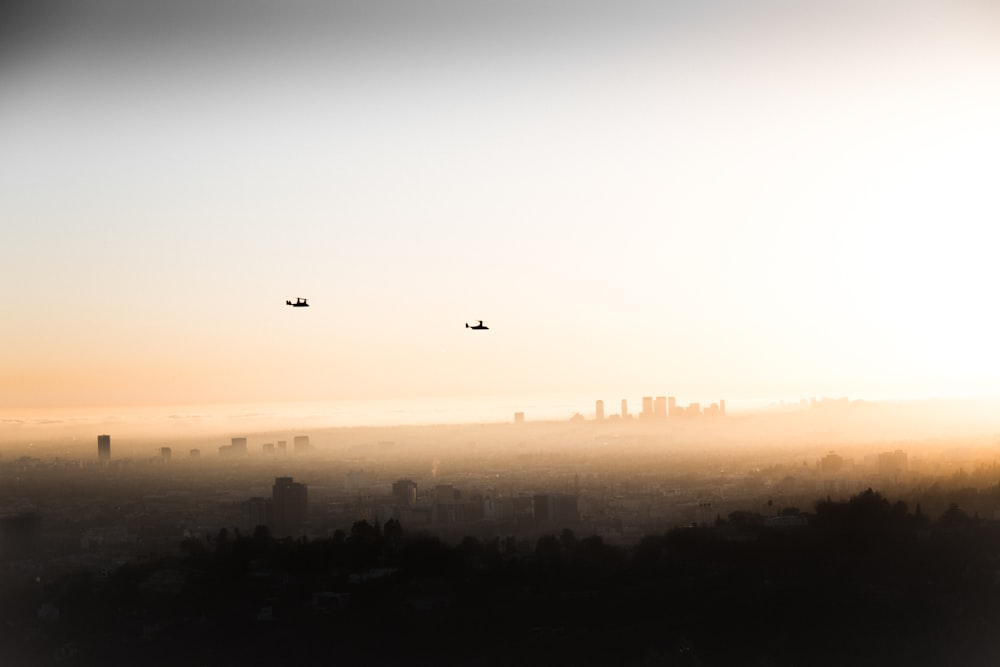 two helicopters flying over the city