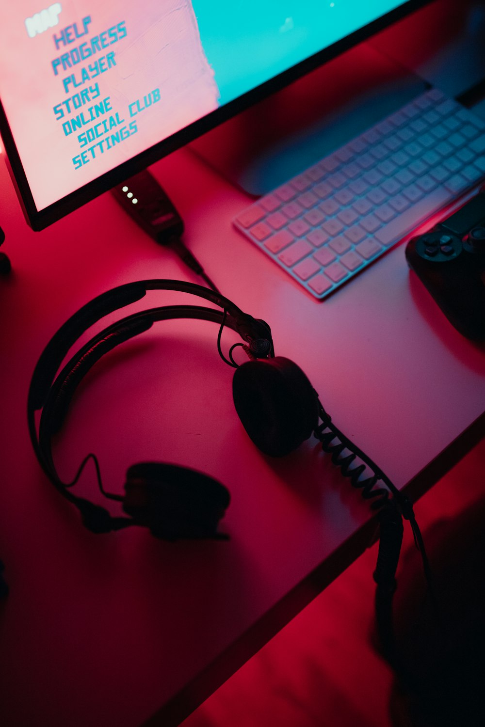 black corded gaming headset beside black flat screen computer monitor turned on