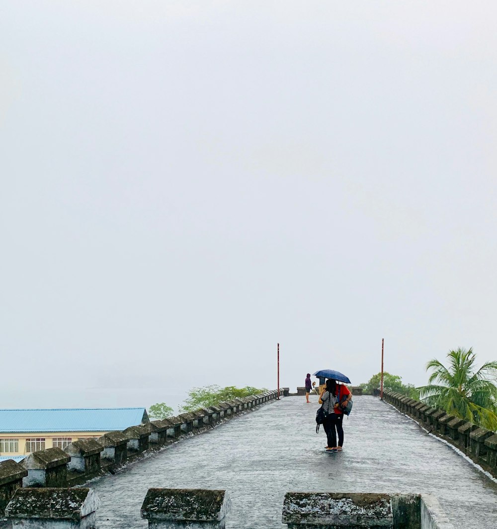 casal coberto por guarda-chuva