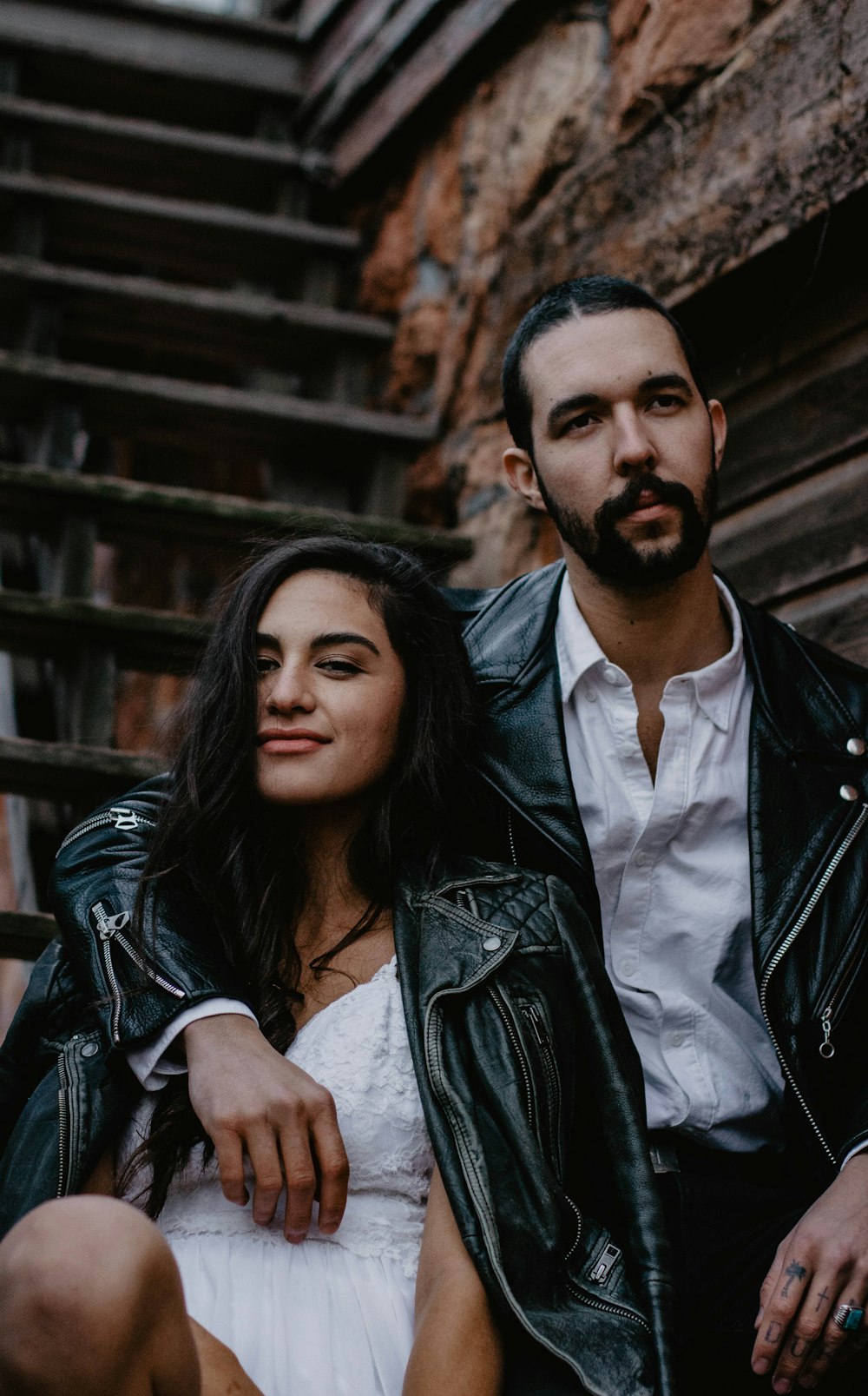 woman smiling beside man wearing black leather jacket