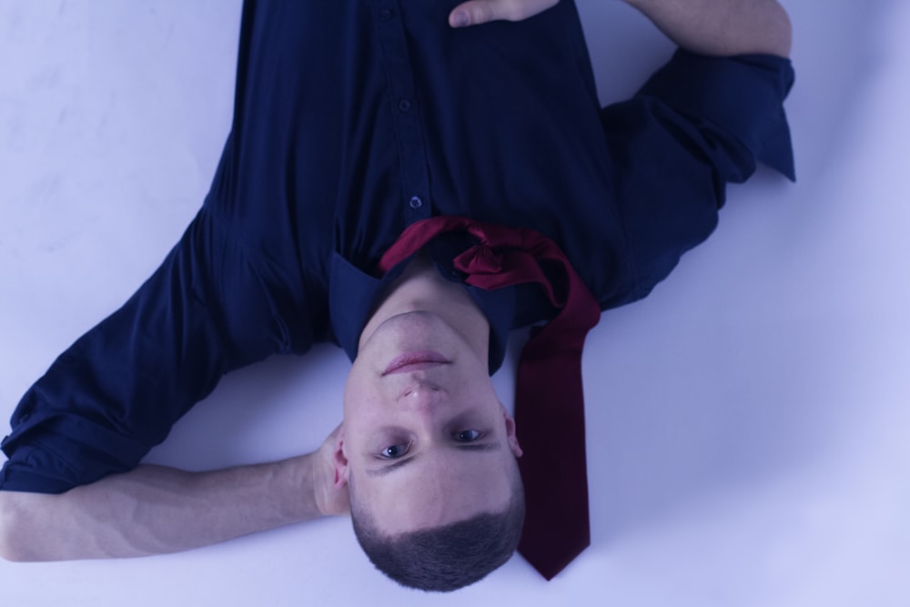 man lying on white surface