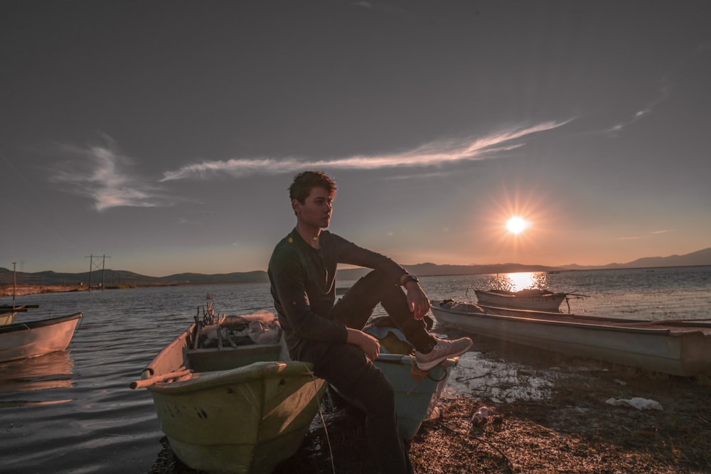 man sitting on canoe boat