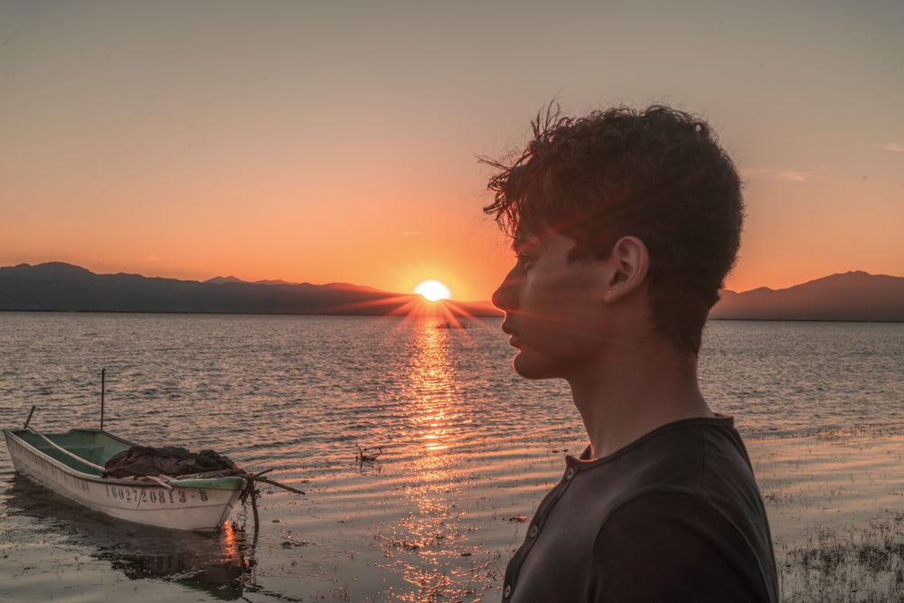 man wearing black crew-neck shirt during sunset