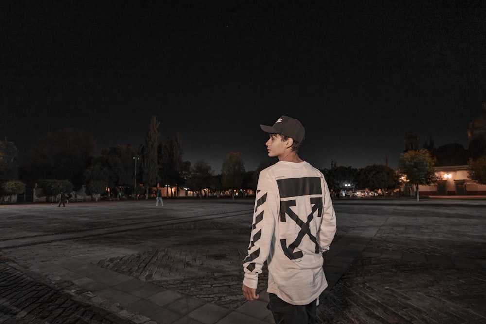 man wearing Off-White long-sleeved shirt standing during nighttime