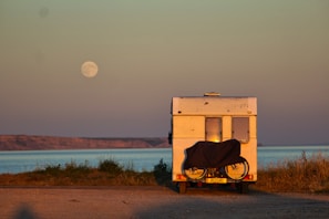 The campervan parked on a beach with waves gently rolling in nearby