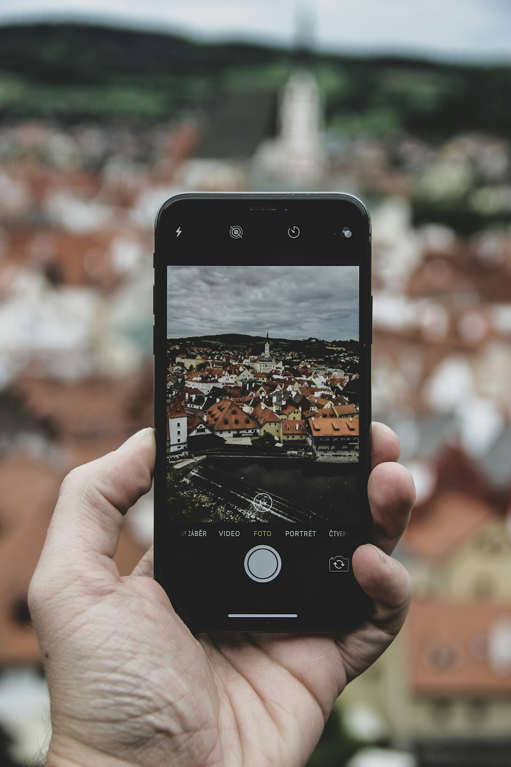 person holding iPhone while taking photo of cathedral