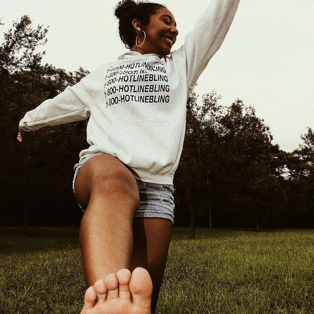 woman standing while wearing white sweatshirt