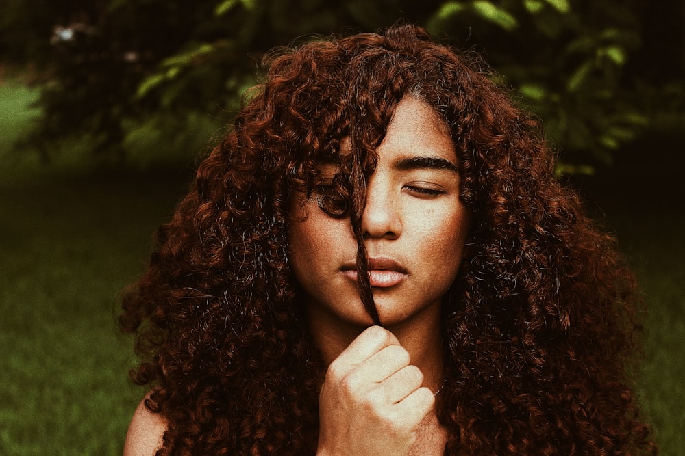 woman holding her hair on front of her face