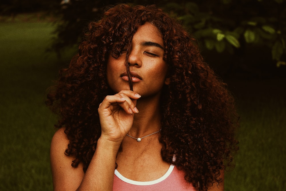 curly haired woman wearing white and red tank top