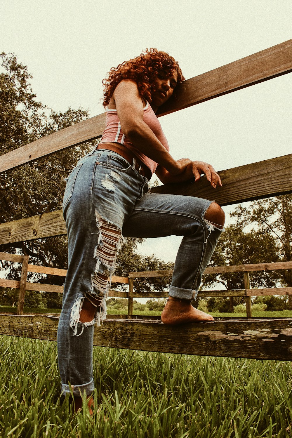 woman standing beside wooden fence