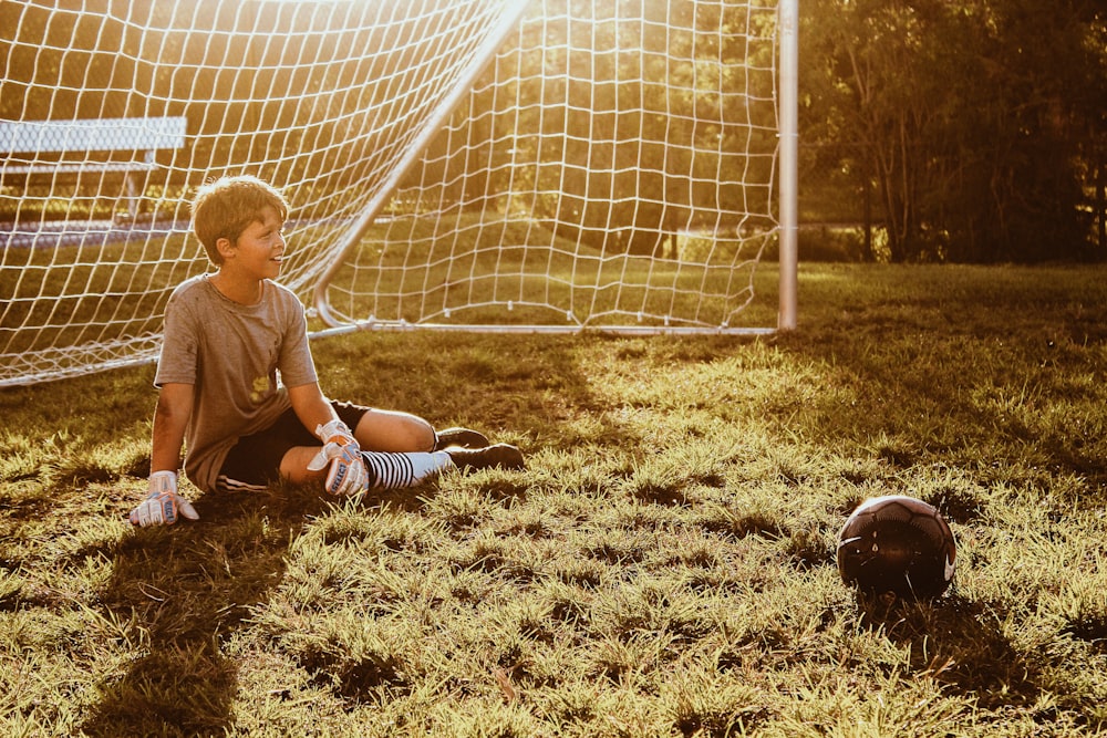 goal keeper sitting on grass field