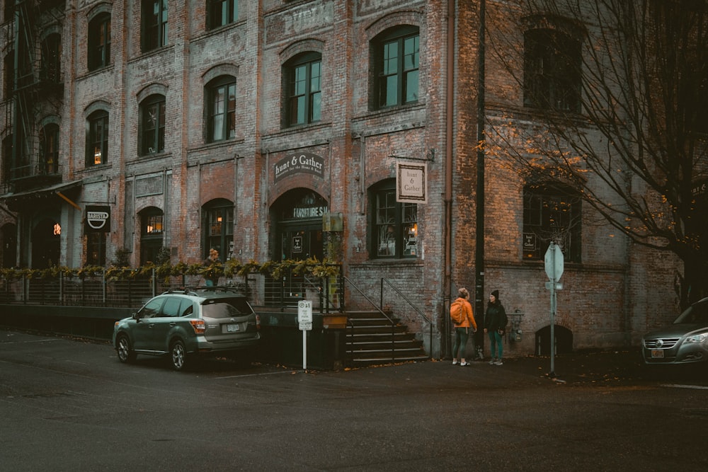 茶色のコンクリートの建物の脇に駐車された銀色のSUV