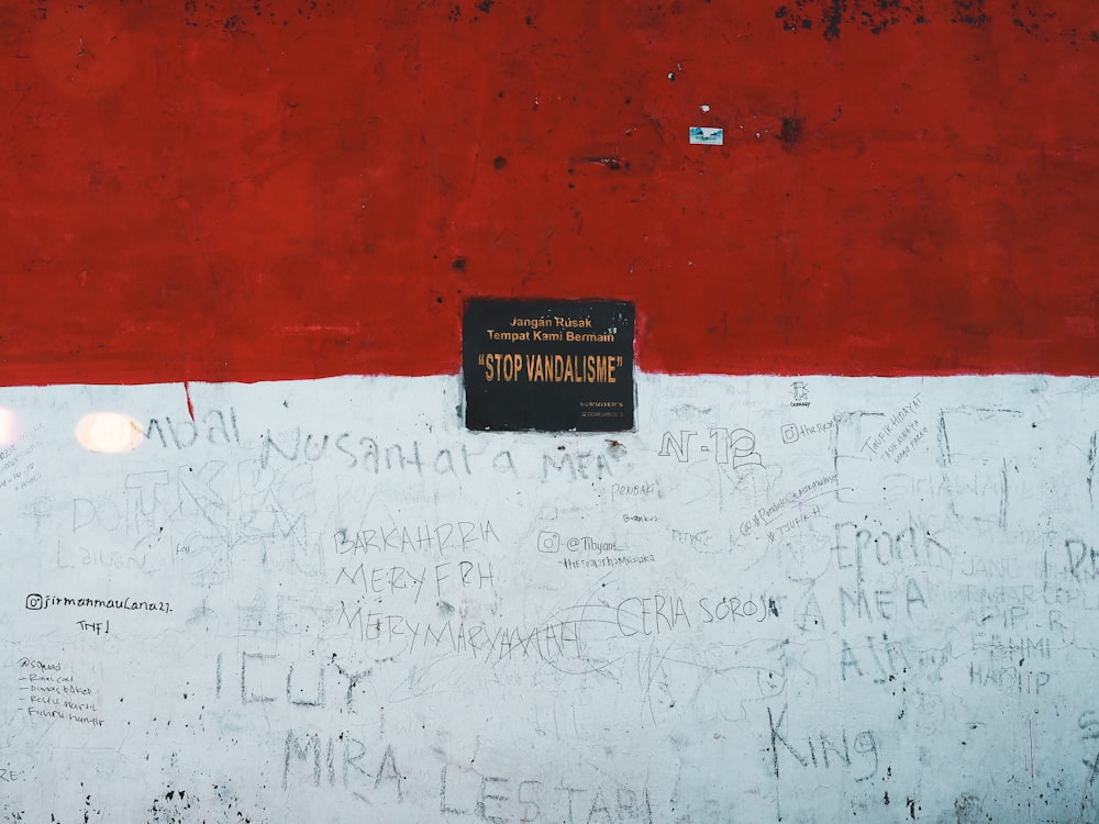 a red and white wall with writing on it