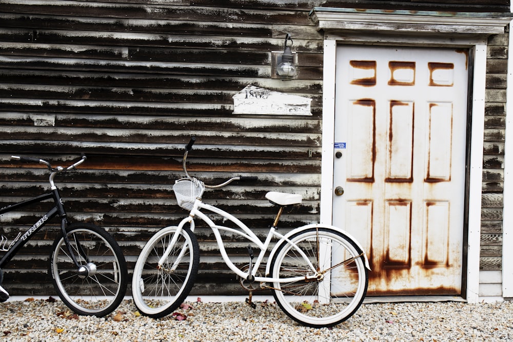 흰색 나무 문 옆에 주차 된 흰색 순양함 자전거
