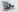 opened MacBook Air beside smartphone, potted plant, and camera lenses