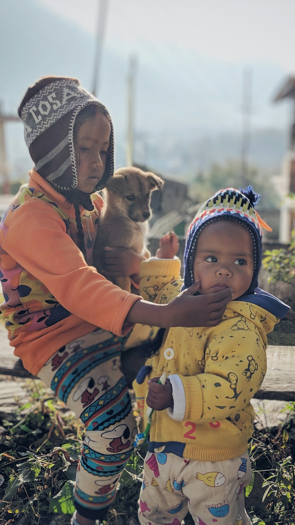 niño sosteniendo un cachorro marrón