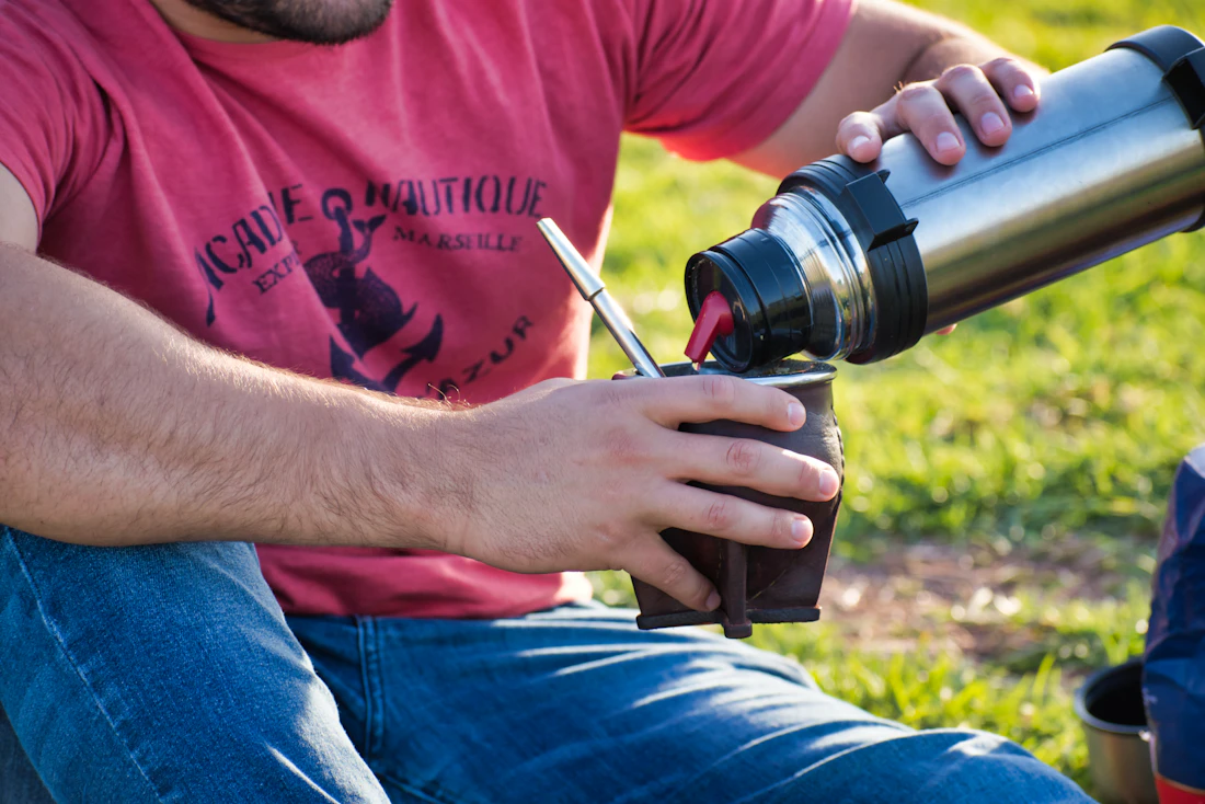 Cebando un mate, agua cayendo desde la pava sobre la yerba