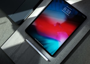 black iPad with white stylus pen