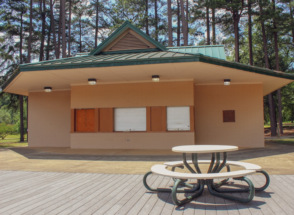 picnic table in front of concrete building under tree at daytime