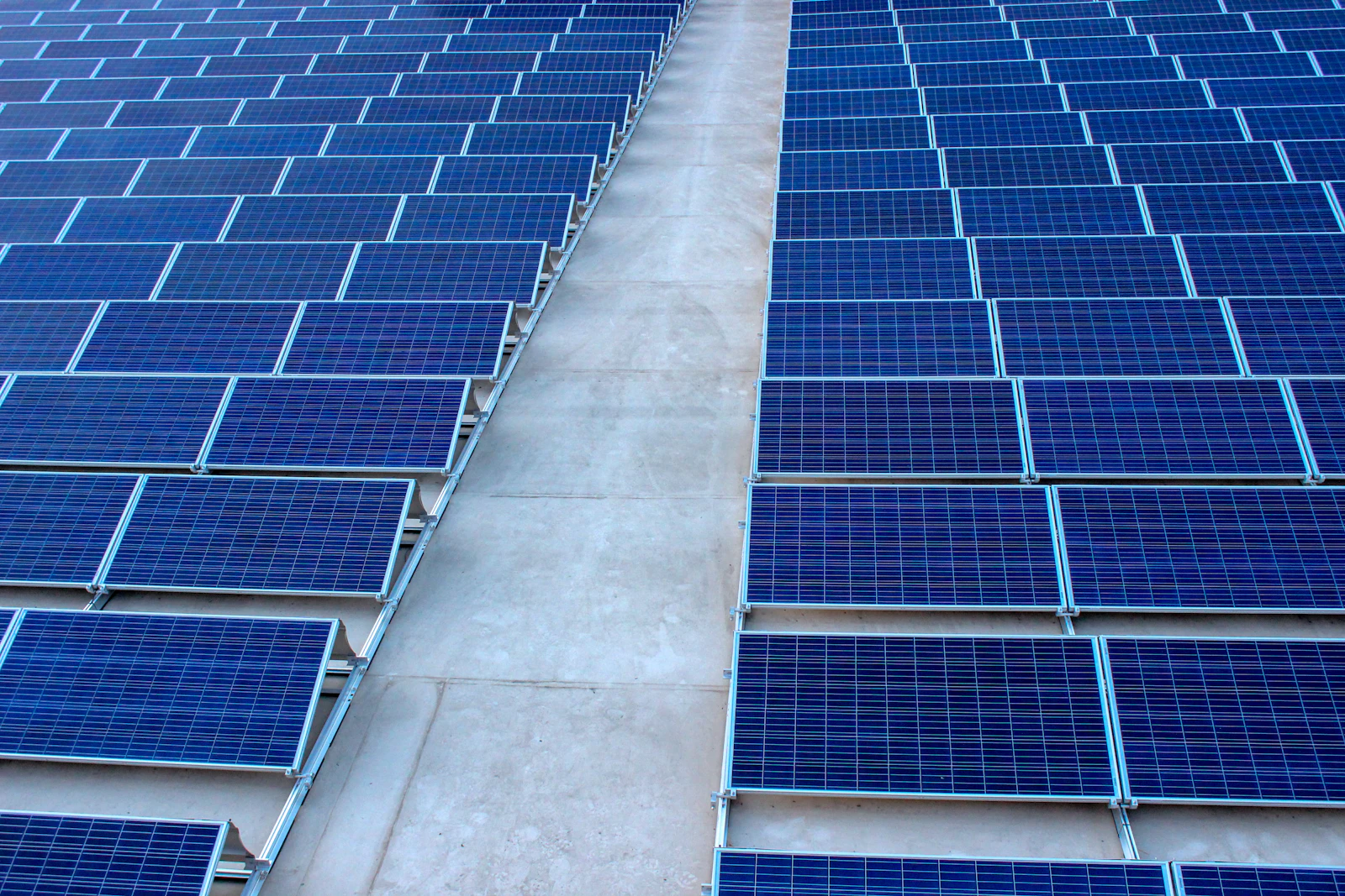 Solar panels being lifted onto a commercial rooftop
