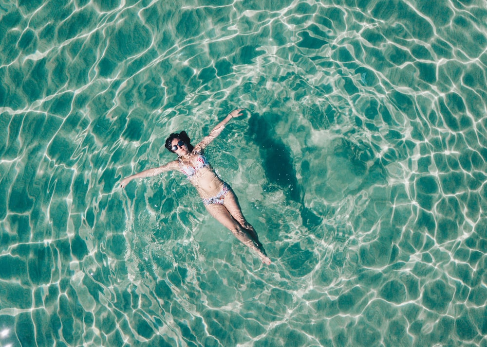 woman floating on body of water