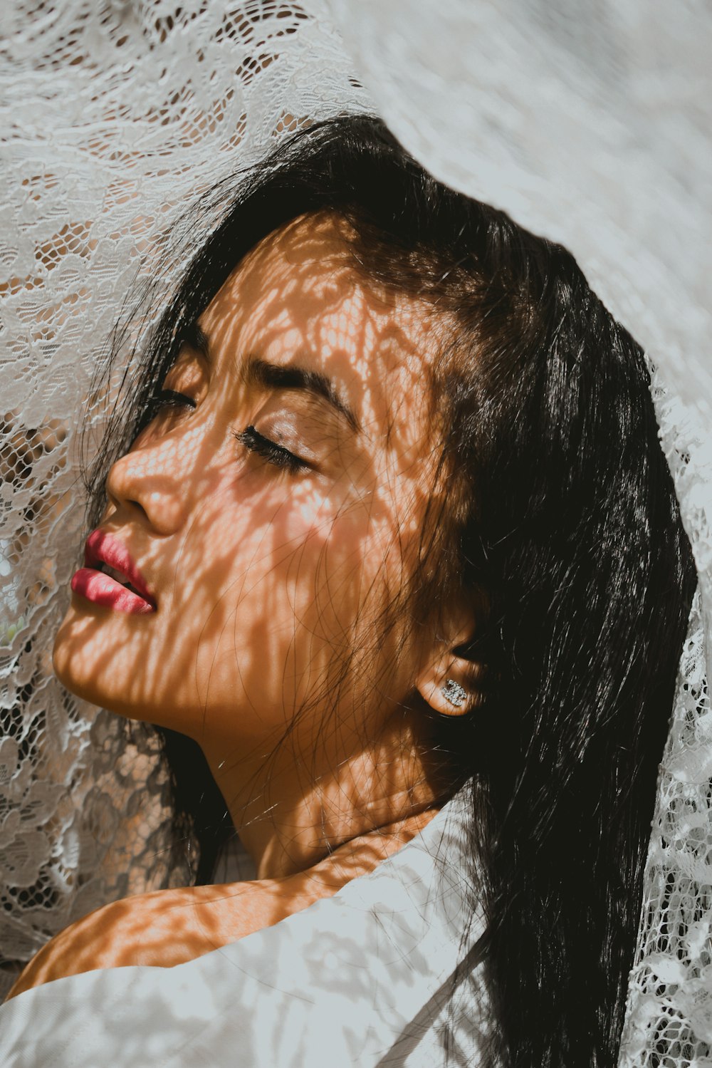 white lace covering woman in white top and red lipstick