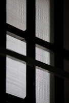 Close-up of premium mosquito net installed on a window with bright background.