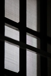 Close-up of a modern black mosquito net installed on a window.