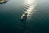 Aerial shot of a sailboat cutting through the calm, shimmering waters near Croatia.