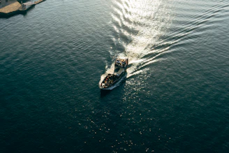 Aerial shot of a sailboat cutting through the calm, shimmering waters near Croatia.
