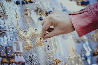 person touching gold earrings