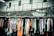 Colorful batik sarongs hanging on a wooden rack in an open market.