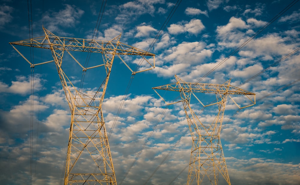 two white metal electric towers under blue sky