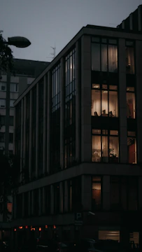 Modern residential building with automated lighting at dusk.
