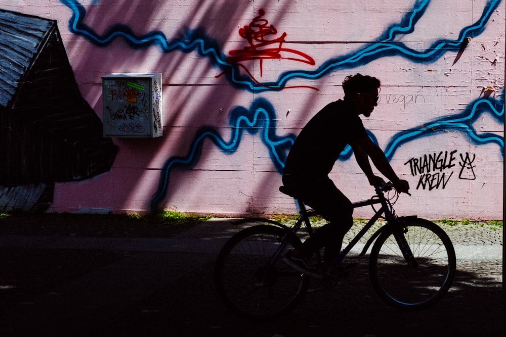 man riding bike near wall