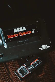 Close-up photo of a vintage Sega Master System console with classic game cartridge inserted.