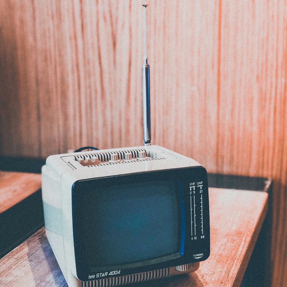 gray CRT monitor on brown wooden surface