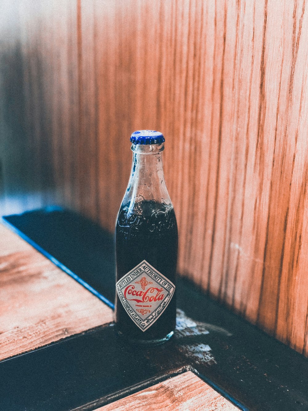 Coca-Cola bottle on brown and black surface